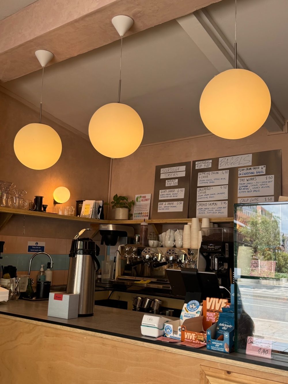 The service counter and back bar, with warm globe pendants and coffee gear